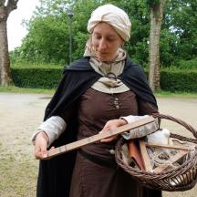 a woman holding a wand and a basket of mushrooms