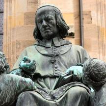 una estàtua d'una dona i nens davant d'un edifici