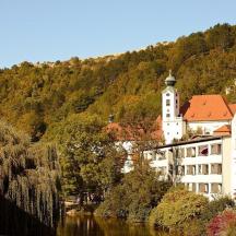 a building on the side of a hill next to a river