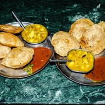 a table with two pans of food with bread and dips