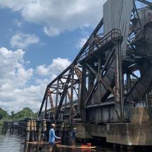 two people standing under a bridge in the water
