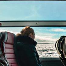 ein Mann, der auf einem Boot sitzt und auf das Wasser hinausblickt