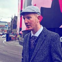 a man wearing a hat and a suit and tie