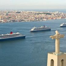 a statue of a cross with ships in the water