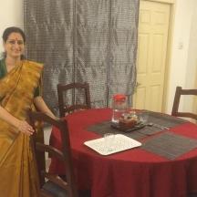 a woman standing next to a table with a red table cloth