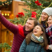 un gruppo di persone in posa per una foto davanti a un albero di Natale