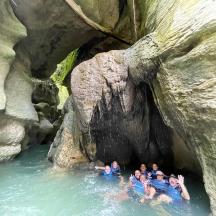 a group of people in the water in a cave