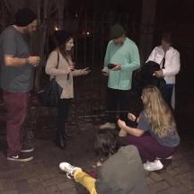 a group of people standing around looking at their cell phones