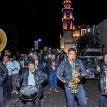 Un grupo de personas caminando por una calle con instrumentos.