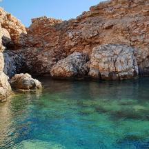 a body of water next to a rocky cliff