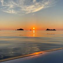 una posta de sol a l'aigua amb un vaixell