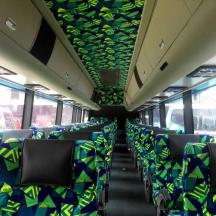 an empty bus with blue and green chairs on it