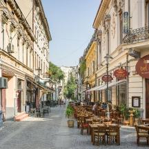 an empty street with tables and chairs and buildings
