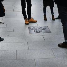 a group of people standing around a drawing on the ground