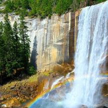 a waterfall with a rainbow on the side of a mountain