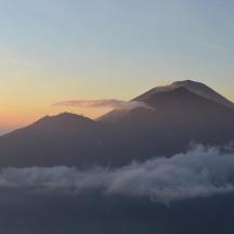 a view of a mountain with clouds in front of it