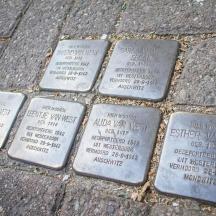 a group of metal squares on a brick sidewalk