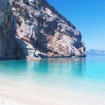 пляж зі скелею та човном у воді