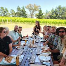 a group of people sitting at a table eating pizza