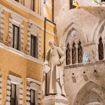 a statue of a man standing in front of a building