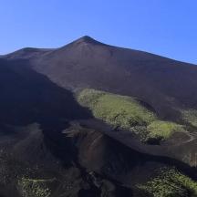 an aerial view of a mountain with green vegetation