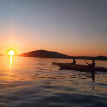 due persone in canoa sull'acqua al tramonto