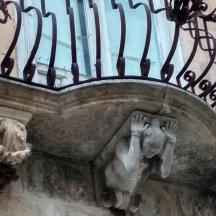 a statue of a person under a balcony