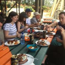 a group of people sitting at a table eating food