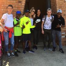 a group of people standing next to a brick wall
