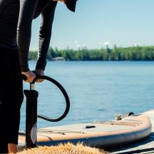 a person holding an umbrella next to a paddle board