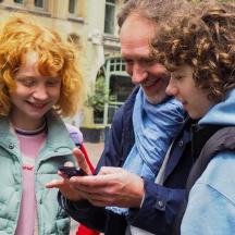 eine Gruppe von Menschen, die auf ein Mobiltelefon schauen
