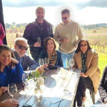 a group of people sitting around a table with wine glasses
