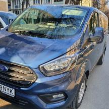 en blå varevogn parkeret på siden af en vej
