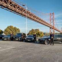 eine Gruppe von Menschen steht auf einem Parkplatz unter einer Brücke