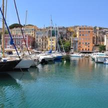 a group of boats docked in a harbor with buildings