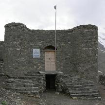 a stone building with a door on a mountain