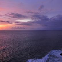 a group of people standing on a cliff overlooking the ocean