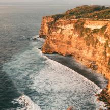 an aerial view of the ocean and a cliff