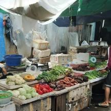 un groupe de personnes rassemblées autour d'un marché de légumes