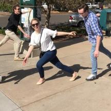 a group of people playing frisbee on a sidewalk