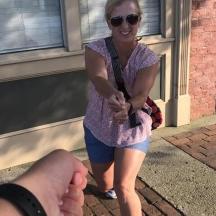 a woman is walking down a street with a man