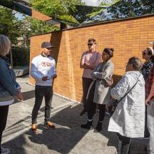 a group of people standing next to a brick wall