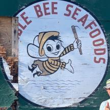 a man standing in front of a bee search sign