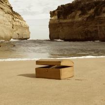 a box sitting on the beach near the ocean