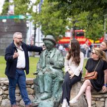 a group of people standing around a statue in a park