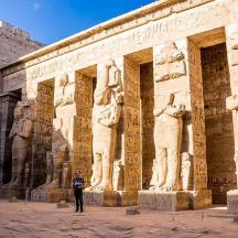 a man standing in front of a building with statues