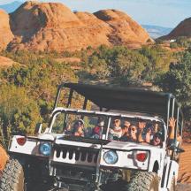 eine Gruppe von Menschen, die in einem Jeep durch die Wüste fahren
