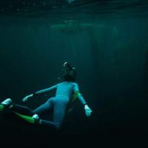 a woman swimming in the water in the dark