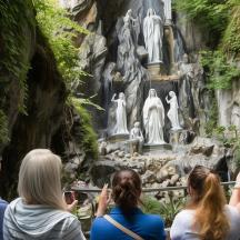 a group of people looking at a statue in a waterfall
