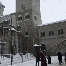 un gruppo di persone in piedi fuori da un edificio nella neve